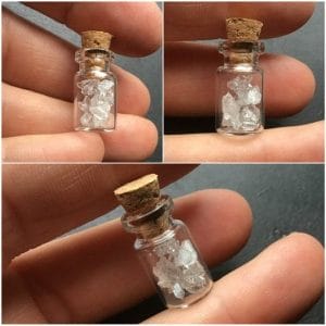 Petite fiole en verre remplie de cristaux de quartz